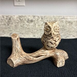 Ceramic owl figurine perched on a branch